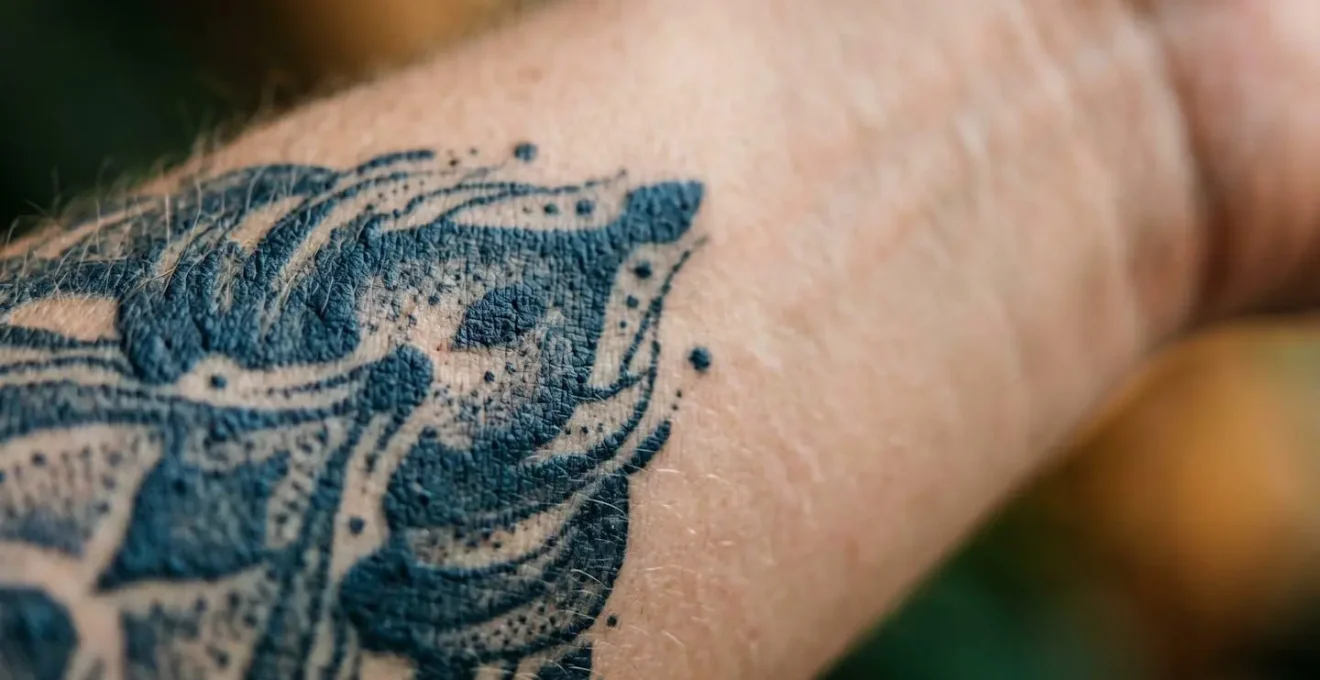 Gros plan artistique sur une zone de peau tatouée en cours de traitement laser de détatouage, avec mise au point sélective sur la texture cutanée