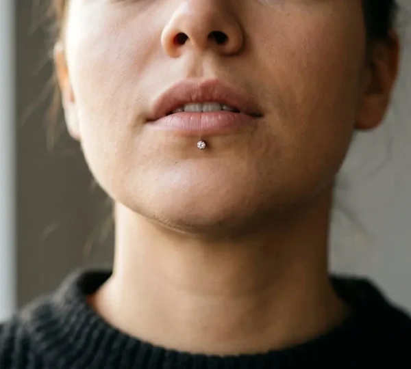 Gros plan artistique d'un menton harmonieux avec piercing labret centré mettant en valeur l'équilibre facial